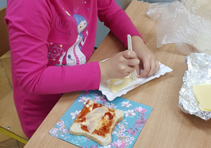 Uczennica wycina łódkę z sera