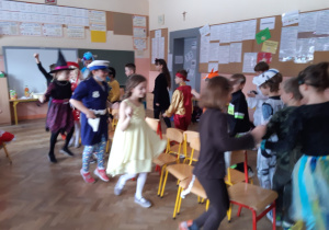 Uczniowie tańczą wokół krzeseł.