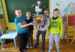 Czterech uczniów ze swoim robotem.