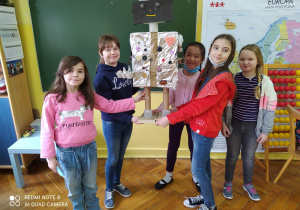 Pięć dziewczynek trzymających wspólnie jednego, dużego robota.
