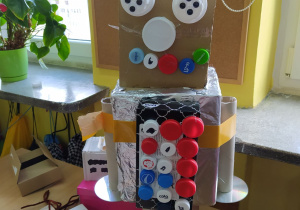 Kolorowy robot z pudeł i plastikowych korków.