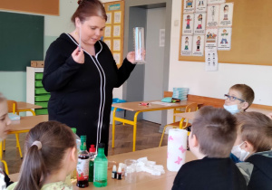 Nauczyciel udziela objaśnień uczniom siedzącym przy ławce