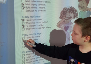 Uczeń pracuje przy tablicy multimedialnej, uzupełnia ćwiczenie