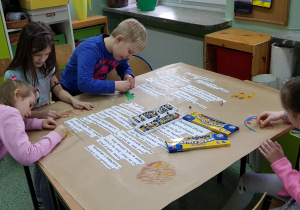 Uczniowie pracują przy ławkach- tworzą kartę pracy grupy