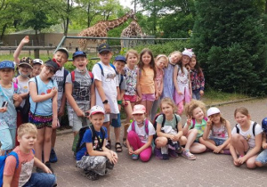 Grupowe zdjęcie na tle wybiegu dla żyraf
