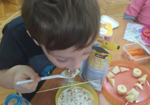 Uczeń spożywa śniadanie przy stole