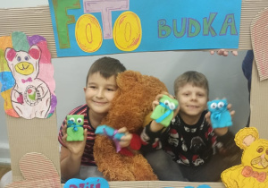 Dwóch uczniów fotobudce z misiem