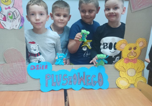 Czterech uczniów fotobudce z misiem