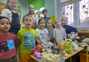 Grupa uczniów przy stole z pluszakami