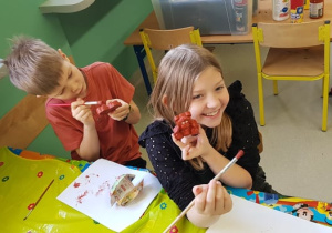 Uczeń i uczennica klasy 2a malują swoje misie