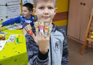 Uczeń z paluszkowymi pacynkami misiów