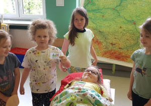 Dzieci opiekują się chorą koleżanką.