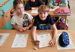 Uczniowie wykonują zadania w karcie pracy.