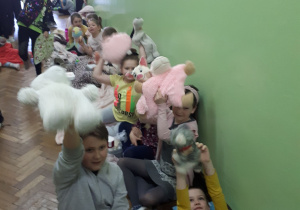 Uczniowie klas młodszych z maskotkami