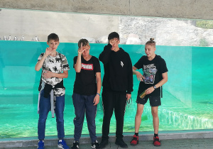 Czterech uczniów klas ósmych na tle akwarium