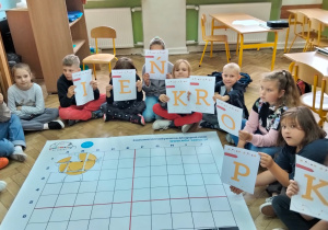 Uczniowie z kartonami w dłoniach