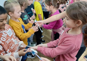 Grupa dziewczynek wręcza chłopcom prezenty