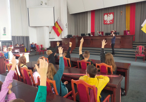Uczniowie biorą czynny udział w debacie w sali obrad Rady Miejskiej.