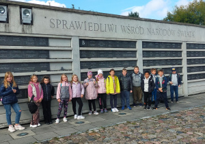 Grupa uczniów przed tablicami Sprawiedliwych Wśród Narodów Świata