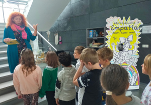 Grupa uczniów z prowadzącą zajęcia przed schodami