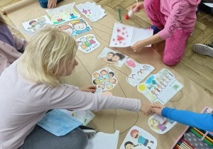 Grupa dzieci pracuje nad wspólną kartą pracy