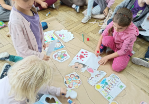 Uczniowie przy pracy nad kartą z szarego papieru