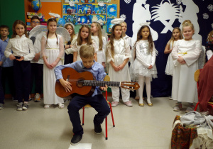 Chłopiec gra na gitarze kolędę pt. Lulajże Jezuniu Marzena