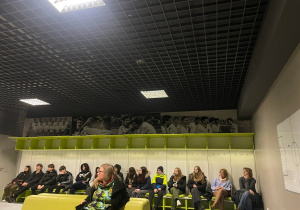 Uczniowie siedzą w szatni dla piłkarzy