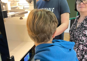 Nauczyciele i uczeń przed drukarką 3D