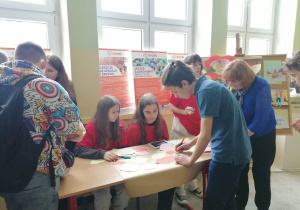Uczniowie zapisują wyrazy na kartkach w kształcie liści.