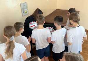 Pani Małgorzata Niemczyk składa autografy na piłkach
