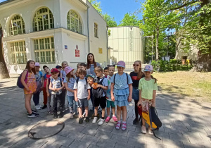 Grupa uczniów z nauczycielką na tle budynku Muzeum.