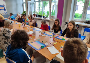 Młodzież i seniorzy w trakcie pracy.