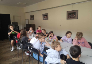Uczniowie klasy 4a przy stole podczas wykładu
