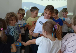 Dziewczynki wręczają chłopakom prezenty.
