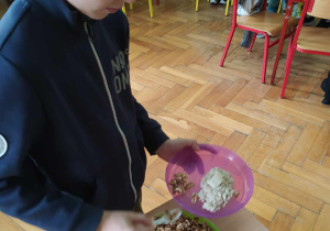 Uczeń nakłada na talerz orzechy.