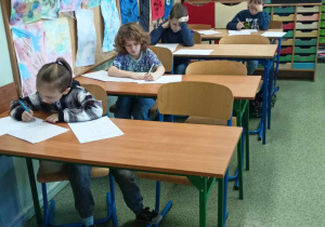 Uczniowie rozwiązują test matematyczny.