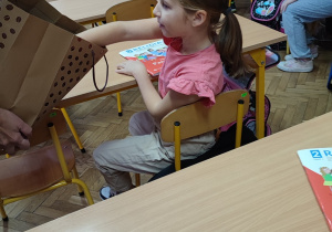 Uczennica częstuje się piernikami