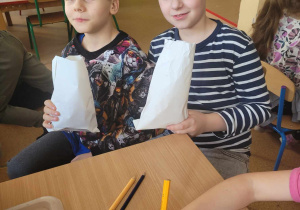 Uczniowie jedzą popcorn.