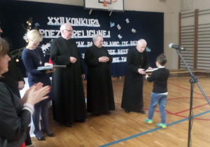 Księża wręczają nagrody laureatom.