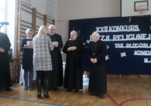 Księża wręczają nagrody laureatom.