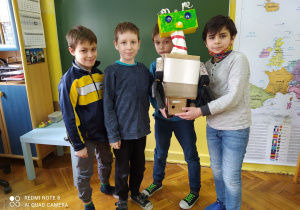 Czterech uczniów z kolorowym robotem.