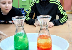 Uczniowie obserwują kolorowe płyny w naczyniach