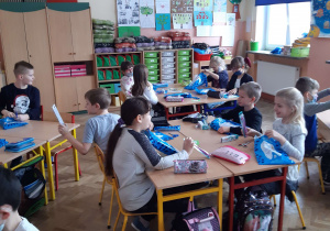 Widok na klasę, uczniowie pracują przy stolikach
