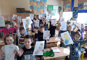 Grupa uczniów klasy 2a z pokolorowanymi, papierowymi skarpetami