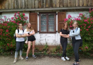 Cztery dziewczynki przed chatą w skansenie.