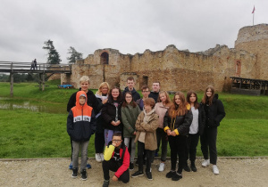 Grupa uczniów 7a z wychowawcą na tle ruin zamku