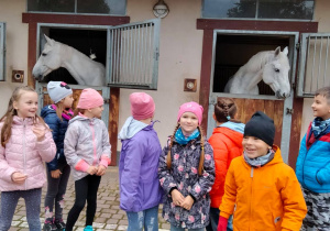 Grupa dzieci, konie w tle