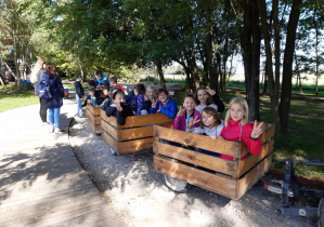 Dzieci siedzące w drewnianych wagonikach