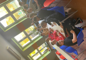 Uczniowie klasy 8b przy stołach w szkolnej stołówce